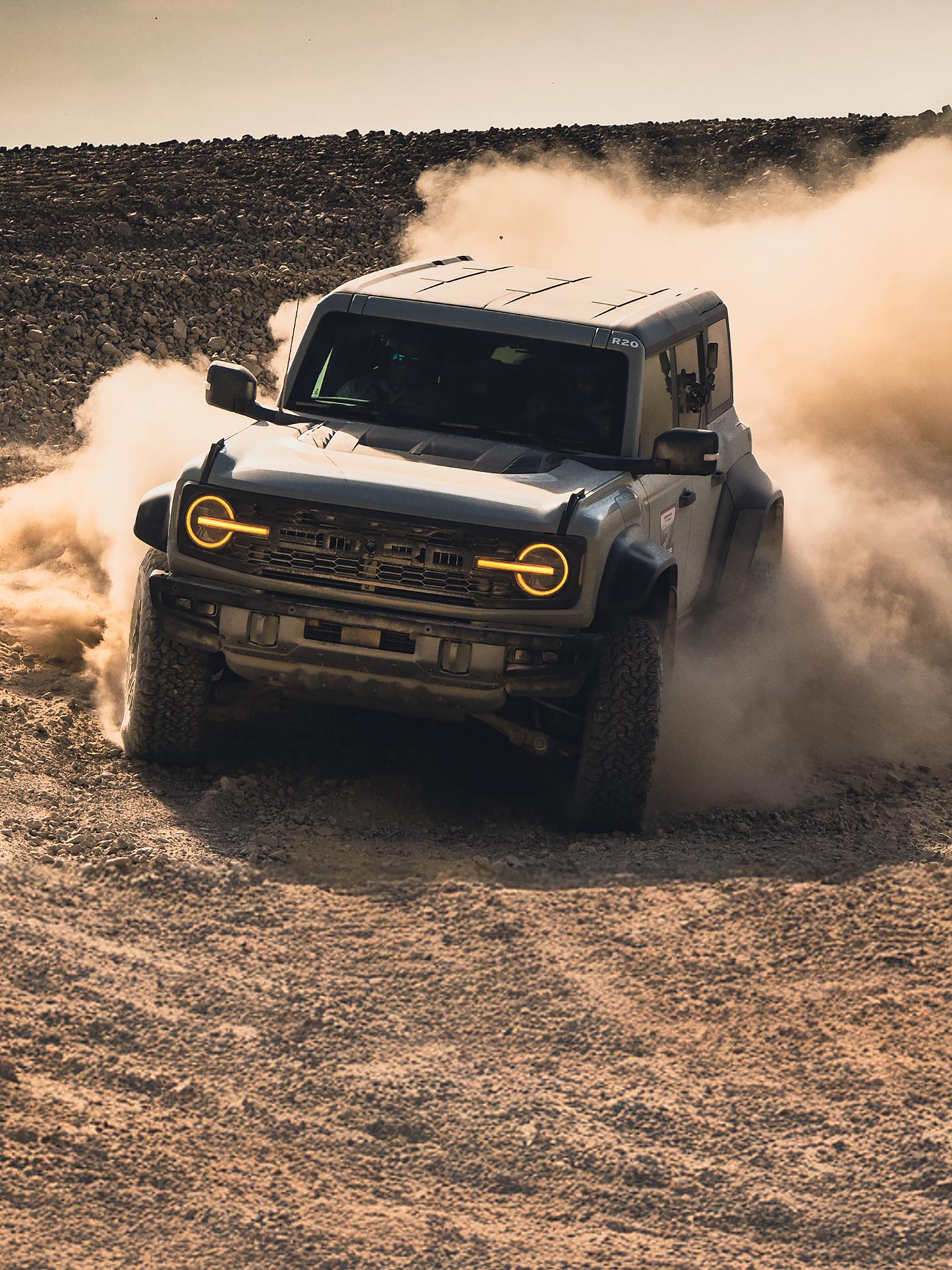 A 2026 Ford Bronco® SUV kicking up dust in a field